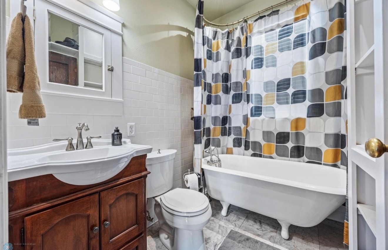 Bathroom — clawfoot tub with subway tile and wood vanity