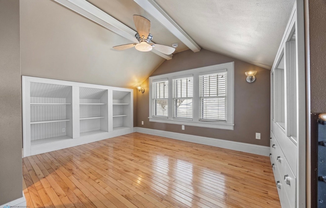 Bedroom — attic suite with built-in shelving, vaulted ceiling and polished hardwood