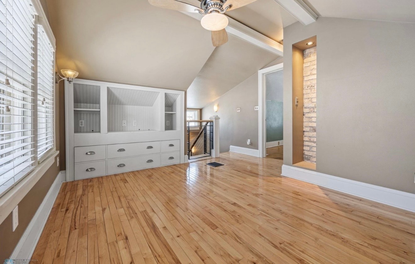 Bedroom — vaulted ceiling with built-in drawers and exposed brick accent
