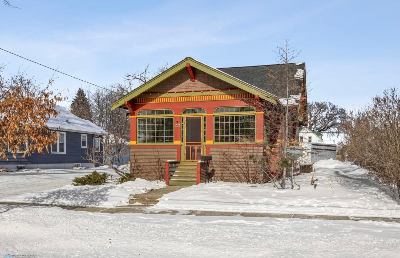 Exterior — colorful craftsman bungalow with arched windows and snow-covered yard
