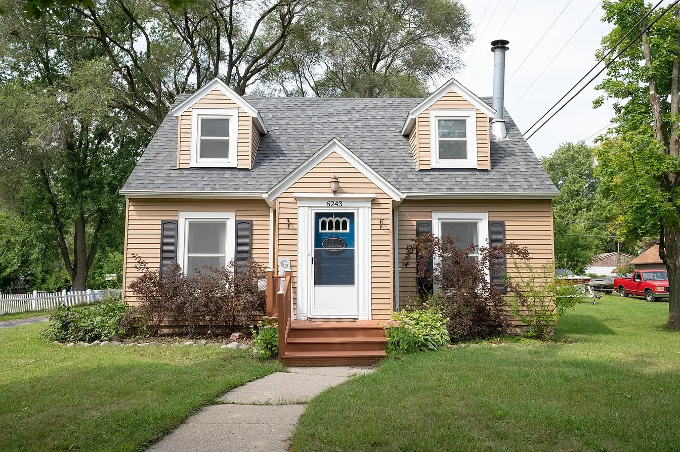 Exterior — gray bungalow with white porch at sunset