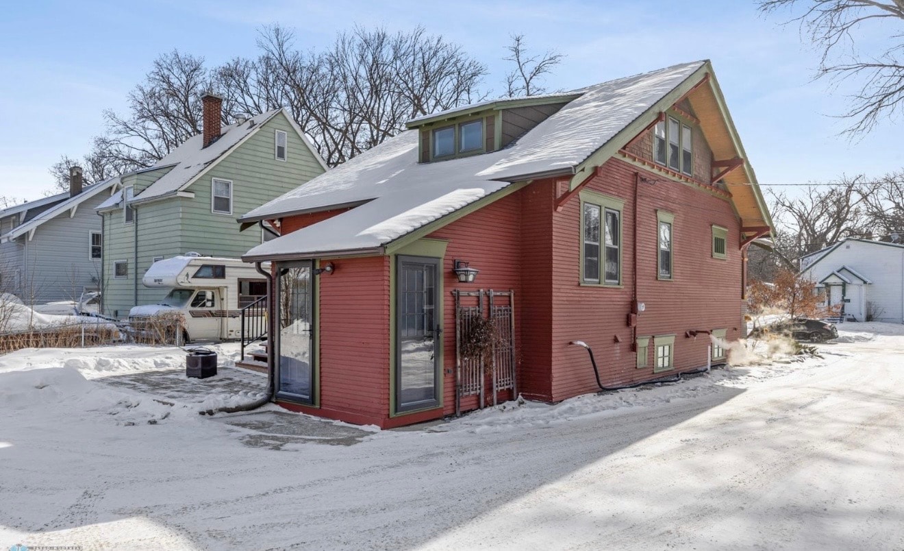 Exterior — red craftsman rear view with sunroom addition and snow