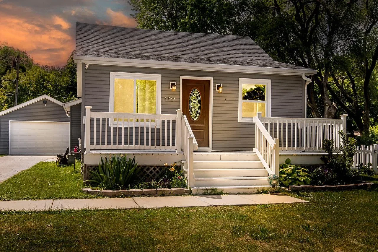 Exterior — tan cape cod with blue door and mature trees