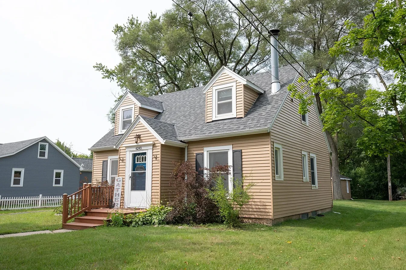 Exterior — tan cape cod with dormers, summer