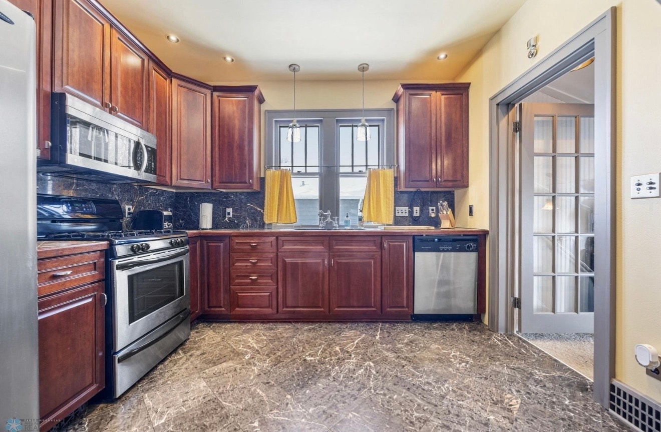 Kitchen — cherry cabinets with yellow curtains, marble backsplash and French door